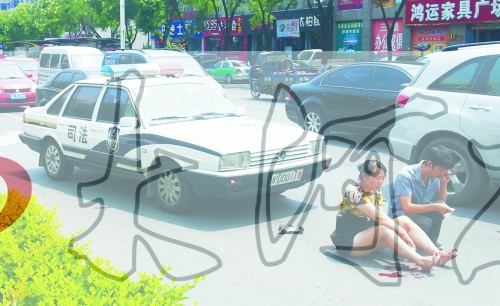 事故發(fā)生后，警車司機(jī)（右）下車查看傷者并撥打120，倆“領(lǐng)導(dǎo)”穩(wěn)坐車內(nèi)引發(fā)圍觀者不滿。