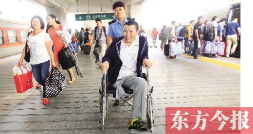 李剛手術(shù)后歸來，在車站工作人員幫助下走出鄭州火車站站臺  東方今報首席記者 張曉冬 攝