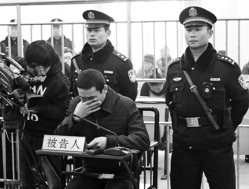 庭審中,29歲的李軍低著頭。