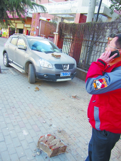 轎車(chē)的前引擎蓋上壓著一塊磚塊