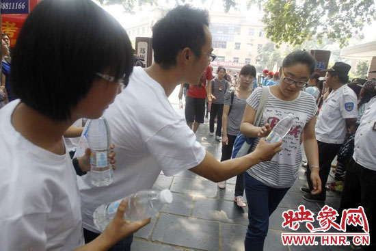 志愿者為剛剛考試完的考生送上1瓶冰凍的冰露·純悅，消暑解渴為考生加油