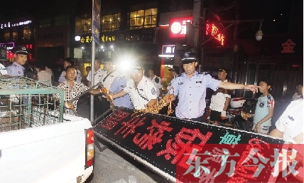 7月8日晚，鄭州市商城路一家占道經(jīng)營的攤販招牌被執(zhí)法隊(duì)員“登記保存”