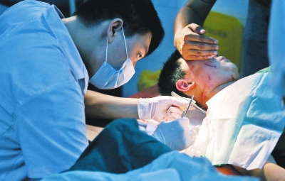 孩子身上有7道傷痕，其中兩道需要縫合，其他的均為擦傷，醫(yī)生正對(duì)他施治。