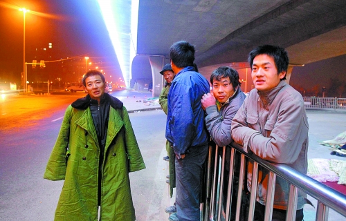 冬夜里，農(nóng)民工在橋下等著干活兒。