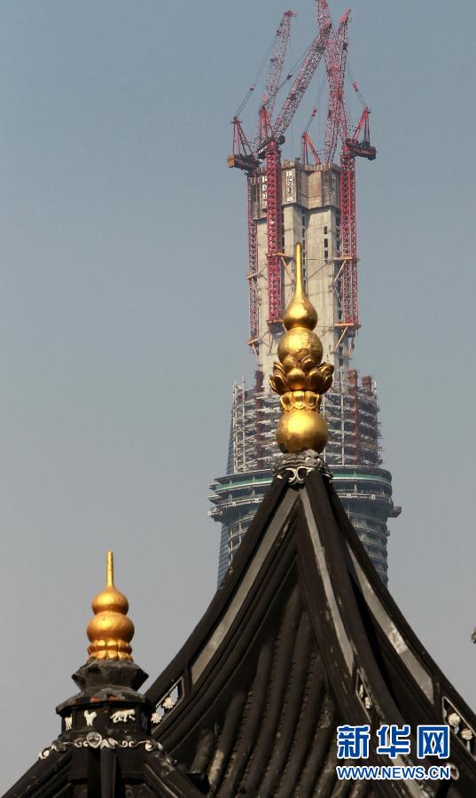 正在建設(shè)中的“上海中心”與豫園地區(qū)的傳統(tǒng)建筑（前）（4月11日攝）。