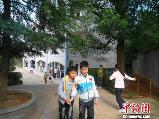 4年來(lái)，13歲的余興泉（左一）每天都攙扶著腿腳不便的同學(xué)左臣進(jìn)出教室、食堂和廁所。 李俊杰 攝