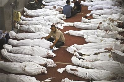8月15日，在埃及首都開羅的一個清真寺，人們在成排的遺體旁哀悼。