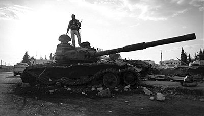 9月8日，敘利亞Zabadani，一名敘利亞反對派武裝人員站在廢棄的政府軍坦克上。