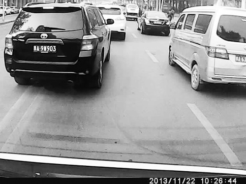 這輛黑色車輛不避讓執(zhí)行緊急任務(wù)的救護(hù)車，并壓著雙黃線變更車道。唐韜/圖