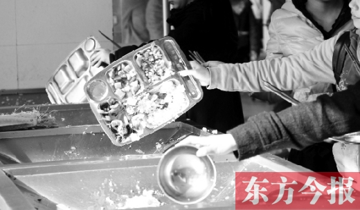 11月27日，河南中醫(yī)學(xué)院餐廳，一名同學(xué)將餐盤內(nèi)沒(méi)吃完的食物倒入餐具回收車內(nèi)
