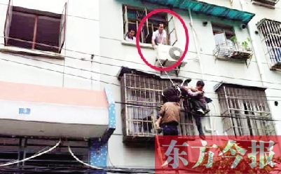 施救現場，劉鵬（圈內）先用繩子捆住老太確保安全 勞動報記者 郭娜 供圖