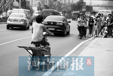 剛駛出隧道口，騎電動(dòng)車的他被交警攔下 邱曉峰/攝