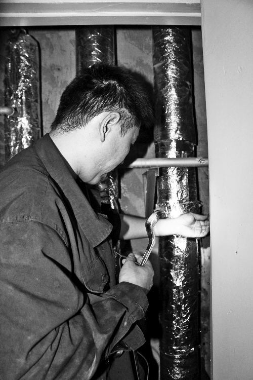 苗師傅一邊進(jìn)行維修，一邊用耳機(jī)接聽市民的電話。