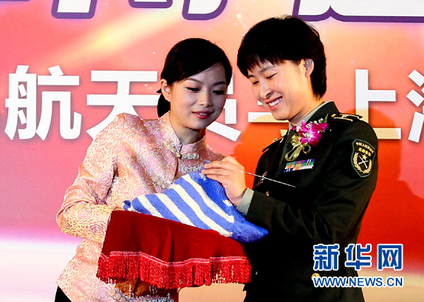 11月1日，航天員劉洋（右）在為“愛心”毛衣編織最后的收尾針。
