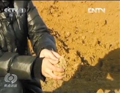 麻剛沙系麻剛石粉碎而成。記者找到一塊麻剛石，一捏就碎成粉末，硬度非常差。央視截圖