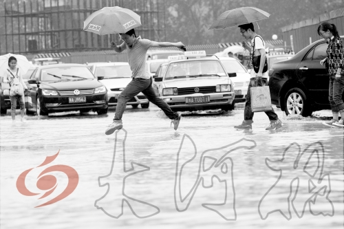 鄭州經(jīng)三路與北環(huán)交叉口處，積水較深，行人們不得不“練輕功”。 記者 白周峰 攝影