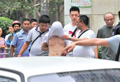 昨日，成都警方抓捕時與毒犯發(fā)生槍戰(zhàn)。一名男犯罪嫌疑人被警方押出。