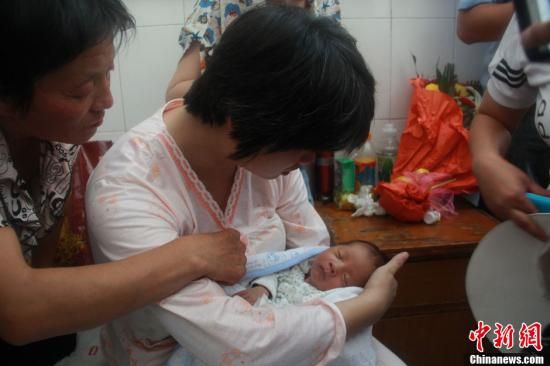 圖為陜西富平“產(chǎn)科醫(yī)生拐賣嬰兒”一案中的被拐嬰兒于8月5日中午在該縣婦幼保健院由當(dāng)?shù)鼐浇挥谄涓改?。張一?攝