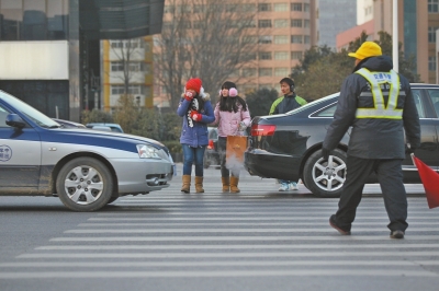 過(guò)斑馬線，行人左顧右盼，汽車寸土必爭(zhēng)。
