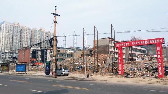 015年5月31日，在社區(qū)干部的帶頭拆遷下，親賢社區(qū)的“城中村改造”拉開帷幕。由于前期“清產(chǎn)核資”及補(bǔ)償標(biāo)準(zhǔn)等因素，拆遷改造工作推進(jìn)并不順利。圖為位于體育西路東側(cè)集體所有的商鋪率先被拆遷完畢，用于遮擋的圍擋正在施工中。（拍攝：2015年9月16日）