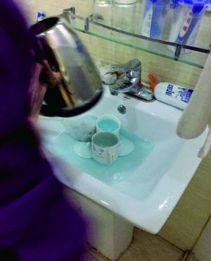 酒店服務(wù)員用潔廁液刷燒水壺和茶杯。