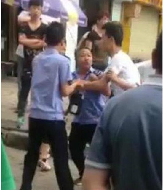 付某（右）與城管執(zhí)法人員廝打在一起。