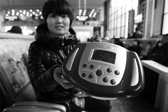 火車站候車室，李女士向記者展示她準(zhǔn)備孝敬父母的按摩儀