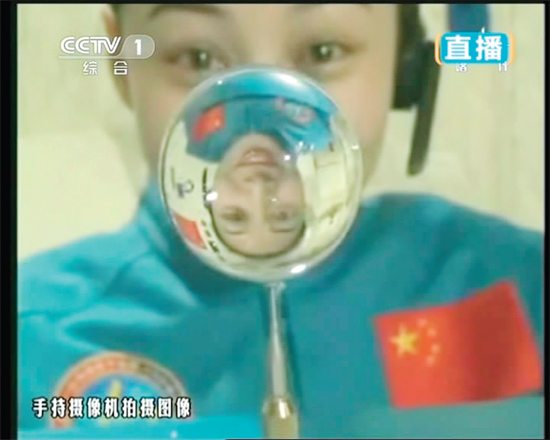 王亞平的倒影出現(xiàn)在水球中。新華社發(fā)（視頻截圖）