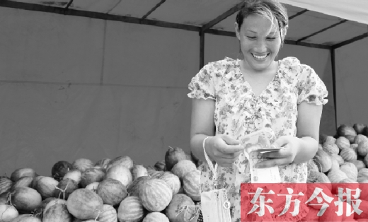 昨日，開封瓜農(nóng)史瑩瑩幸福地數(shù)著賣瓜錢 東方今報記者 沈翔 攝
