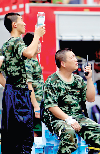 火場外，被消防戰(zhàn)士稱為“李大隊”的救援人員掛著吊瓶現(xiàn)場指揮