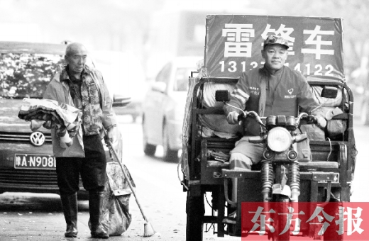鄭州市商城路，一名環(huán)衛(wèi)工懷抱著剛剛收到的毯子，目送“雷鋒哥”孫德坤離開
