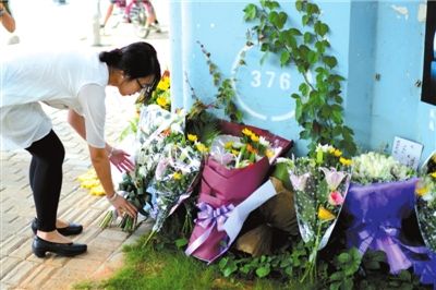 6月8日下午，記者來到廈門公交車爆炸事發(fā)現(xiàn)場橋下，附近已聚集了十幾個自發(fā)前來悼念的市民。橋墩下排放了一圈或黃或白的菊花，還有玖瑰、百合等。