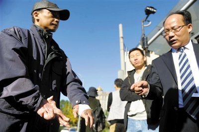 常林鋒在法院外展示雙手，他稱被燙傷的手因刑訊逼供且未得到及時救治