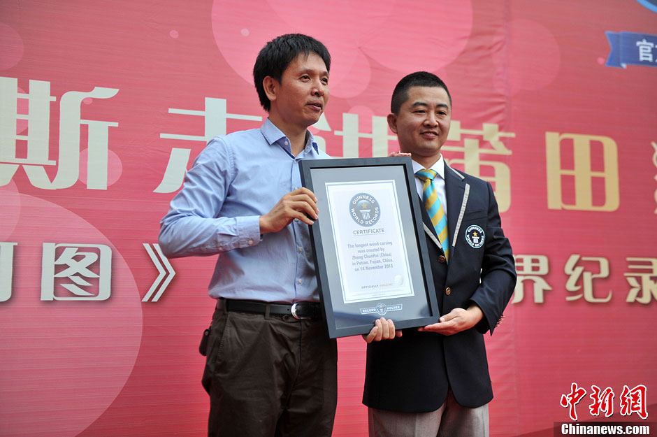 圖為世界吉尼斯認(rèn)證官為鄭春輝（左）頒發(fā)證書。呂明 攝