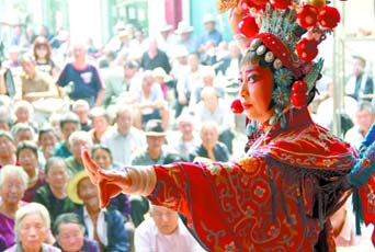 圖為8月15日戲曲演員在“流動(dòng)舞臺車”上表演傳統(tǒng)地方戲《穆桂英下山》。