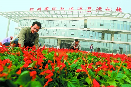 9月23日，工人們正在鄭州國際機(jī)場許昌候機(jī)樓前擺放鮮花。
