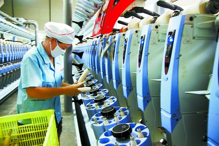 7月3日，在鄧州市永泰棉紡有限公司電腦控制全自動(dòng)紡紗車間，紡織工人正在生產(chǎn)棉紗。
