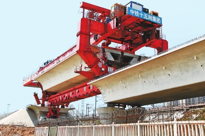 建設(shè)者們操縱巨型起重機(jī)在吊放橋墩。記者鄧放攝