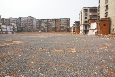 為降塵，旮旯王村拆遷后裸露的地面上鋪了一層石子。
