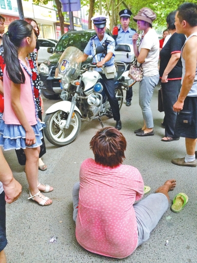 在鄭州優(yōu)勝南路東三街交叉口向東100米處，一名短發(fā)中年女子平躺在路南快車道上，身旁還有一只掉落的拖鞋