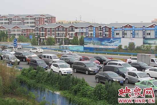記者看到鄭州機場收費站口車輛排隊，與此形成鮮明對比的是，路的對面（另一半幅）卻車輛較少，通行順暢。