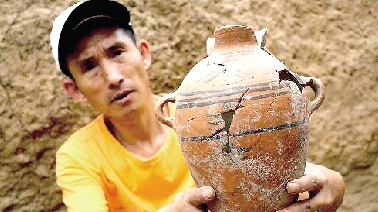 　　考古工作人員展示出土的仰韶文化時期代表性彩陶。