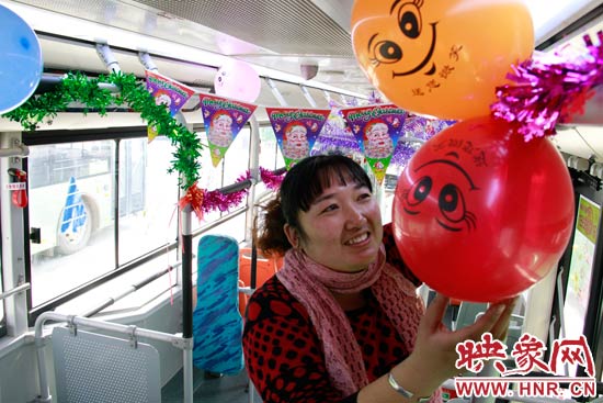 鄭州快速公交B3區(qū)間線車長(zhǎng)李鵬云在車廂里懸掛氣球，布置圣誕車廂，營(yíng)造歡樂圣誕氛圍