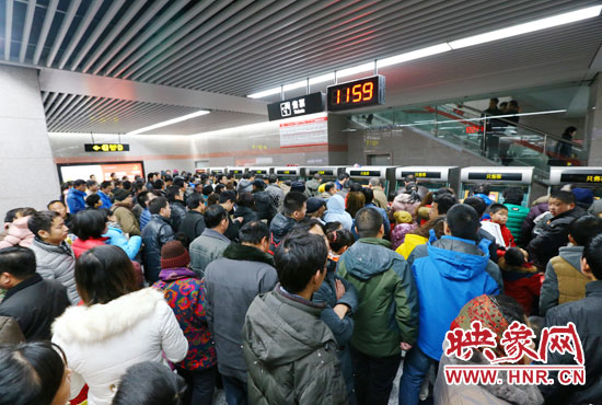 地鐵開通首日，上午十一點五十九分，紫荊山地鐵站售票機前擠滿了買票的市民。