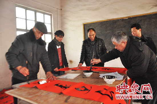 鞏義市魯莊鎮(zhèn)農民書法愛好者正在寫春聯。
