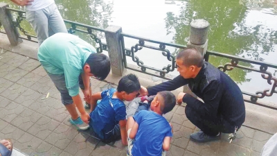 男孩被救出后，圍觀群眾幫他控水換衣服。