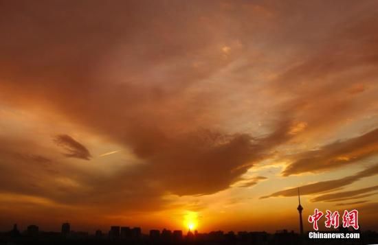 12月8日下午，強(qiáng)烈的西北風(fēng)光臨北京，吹散了籠罩全城上空的霧霾，冬日罕見的艷麗晚霞映紅了半邊天。