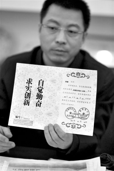 昨日，首師大美術(shù)學(xué)院黨委書(shū)記出示被騙學(xué)生的錄取通知書(shū)，表示“本科”字樣是由招生公司虛假宣傳、擅自添加。新京報(bào)記者 浦峰 攝