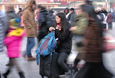 春運(yùn)首日，北京站客流量明顯增多，一名女孩在人流中等待進(jìn)站。