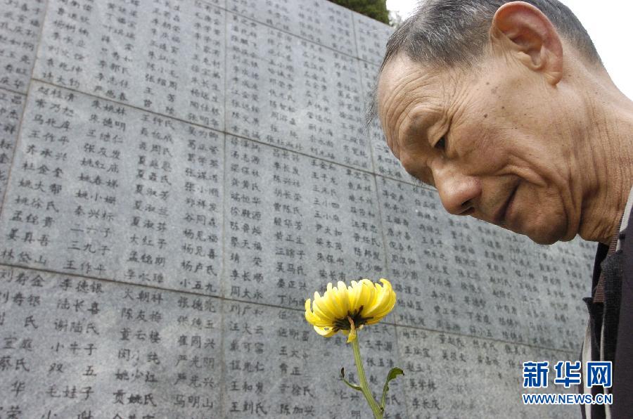 2006年4月5日，74歲的南京大屠殺幸存者佘子清手捧鮮花，祭奠被日軍殺害的母親。